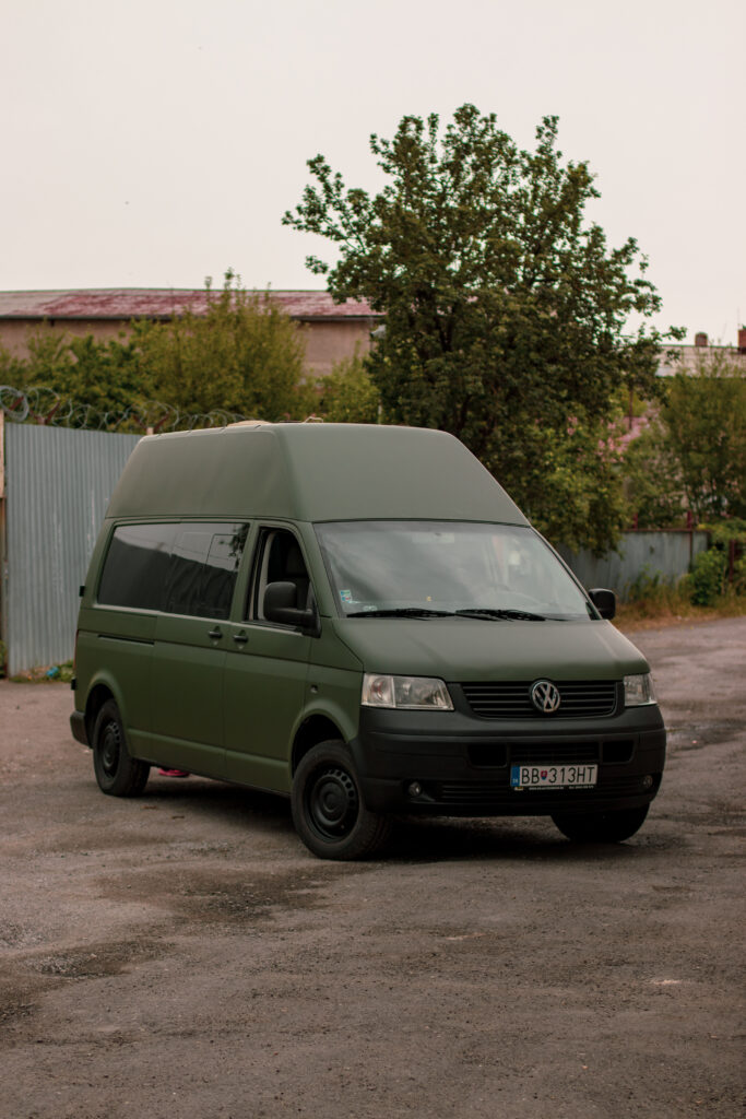Zelená matná dodávka VW Transporter pred dielňou