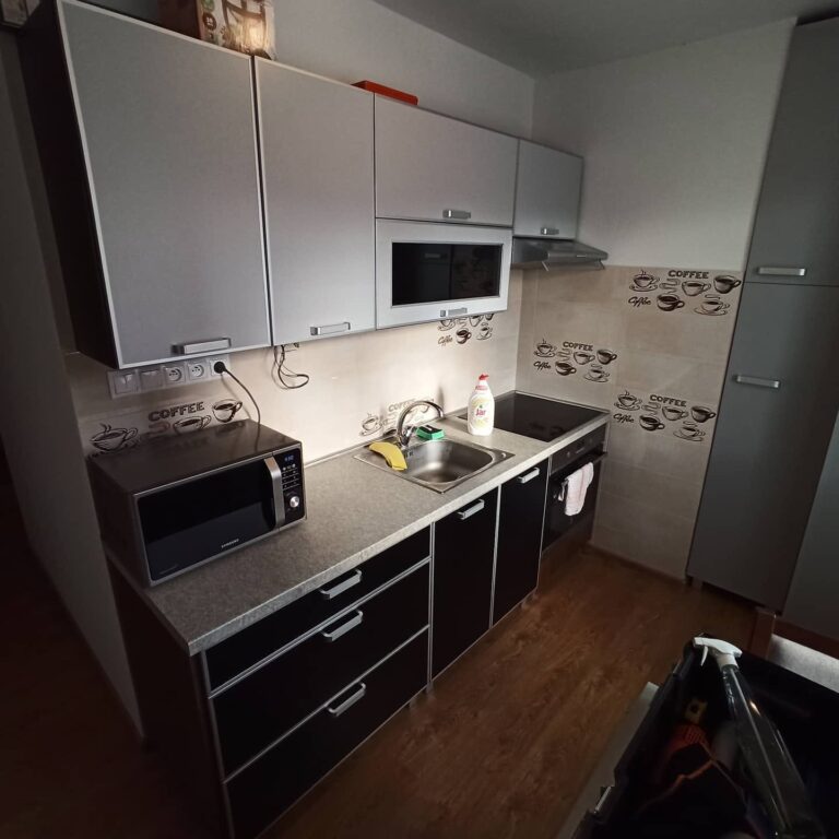 Kuchynská linka po polepe fóliou – horné skrinky šedé, spodné čierne