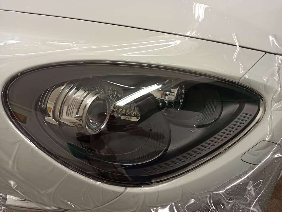 Detail predného svetlometu bieleho Porsche