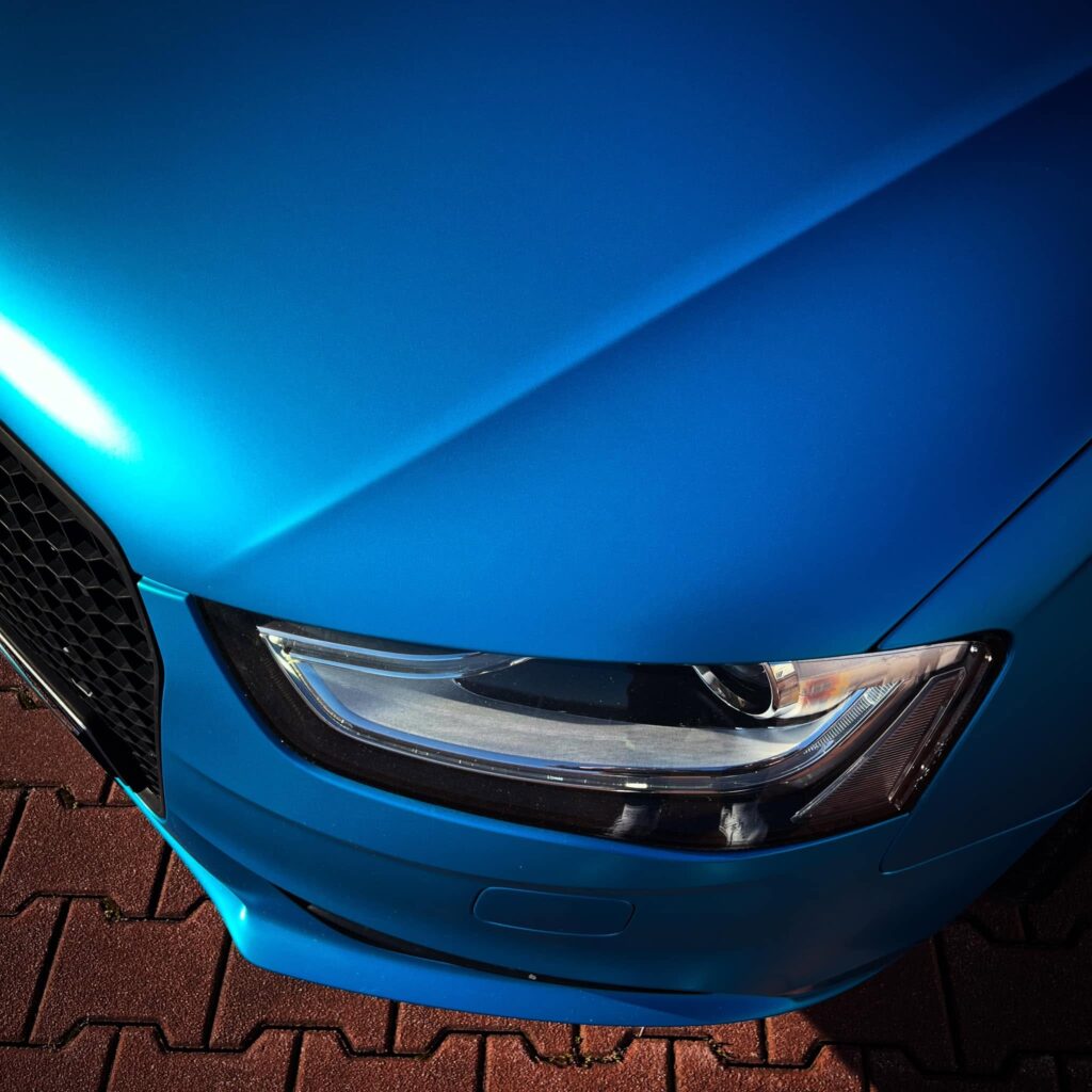 Detail svetlometu a blatníka Audi A4 v saténovej modrej